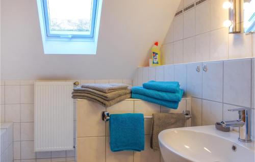 a bathroom with blue towels and a sink at Amazing Apartment In Loxstedt With Kitchen in Loxstedt