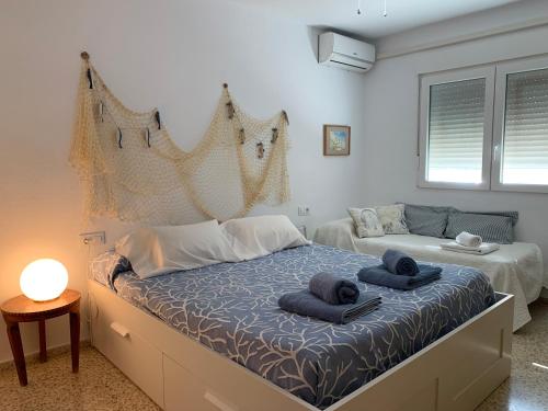 een slaapkamer met een bed met handdoeken erop bij Mi casa de Cádiz in Cádiz