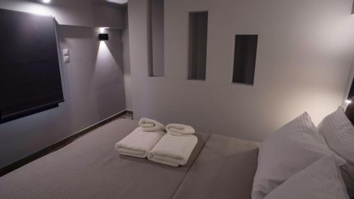 una camera da letto con 2 asciugamani bianchi su un letto di Perla Inn a Stavros