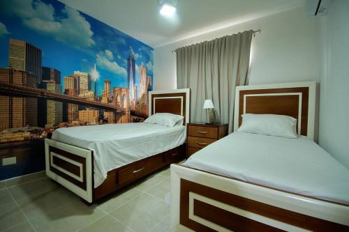 2 camas num quarto com um mural da cidade na parede em The apartment you dreamed of 2 ! em Santiago de los Caballeros