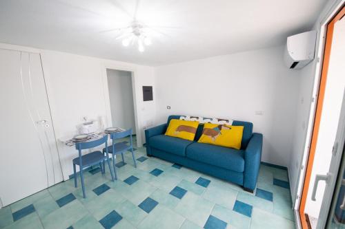 sala de estar con sofá azul y mesa en Villa la Torre Levante en Torre Dei Corsari