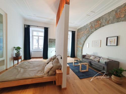 a living room with a bed and a living room with a couch at Larco Trieste studio living 3 in Trieste