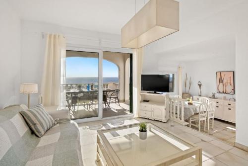 a living room with a couch and a television and a table at Villa Atalis in Son Bou