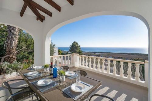 a dining room with a view of the ocean at Villa Atalis in Son Bou