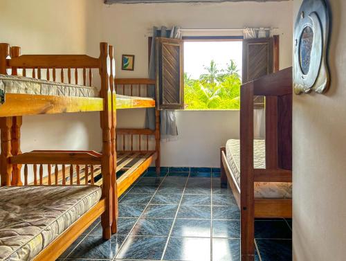 オリベンサにあるIncrivel casa com piscina em Ilheus na Bahiaの二段ベッド2台と窓が備わる客室です。