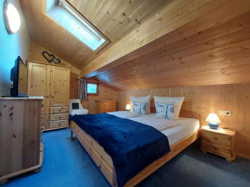 a bedroom with a large bed in a wooden cabin at Bergmomente Montafon Ferienhaus Bitschweil in Tschagguns