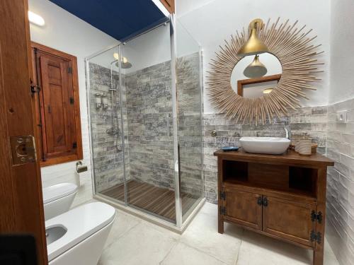 y baño con ducha, lavabo y espejo. en Mdina Casa Rural en Fernán Pérez