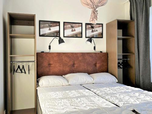 een slaapkamer met een bed met vier foto's aan de muur bij Holiday home SÄLEN XXIX in Stöten