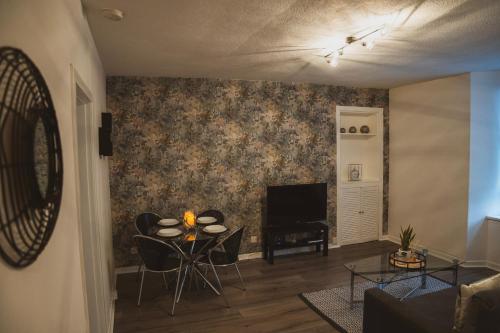 sala de estar con mesa y TV en 1 bedroom flat with easy parking/public transport, en Dundee