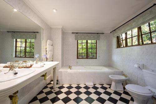 uma casa de banho com uma banheira, um lavatório e um WC. em Halliwell Country Inn em Howick