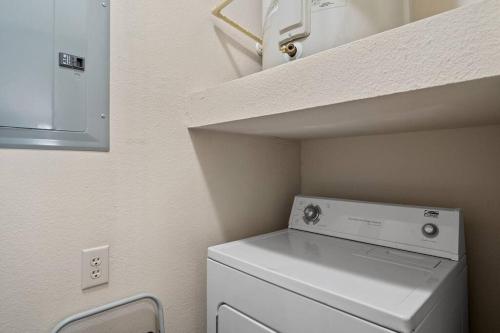 een wasmachine en droger in een kleine kamer bij HEIRS VENTURES: Fantasy . Near DT . WiFi . King Bed . W/D . 55” TV in Oklahoma City