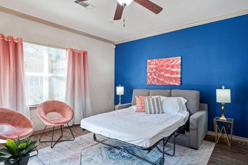 um quarto com paredes azuis e uma cama e duas cadeiras em HEIRS VENTURES: Fantasy . Near DT . WiFi . King Bed . W/D . 55” TV em Oklahoma City
