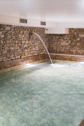 a swimming pool with a water fountain at Quinta de Travassinhos- Douro Valley & Spa in Santa Marta de Penaguião