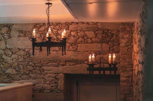 um candelabro com velas penduradas sobre uma lareira em Quinta de Travassinhos- Douro Valley em Santa Marta de Penaguião