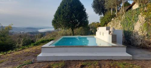 a swimming pool sitting on top of a hill at Casas da Tapada Briteiros Casa das Cortes in Guimarães