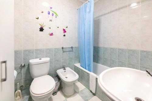 a bathroom with a toilet and a tub and a sink at Aveiro Cozy Apartment in Eixo
