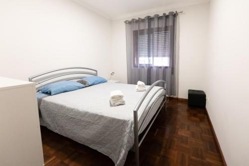 a bedroom with a bed and a window at Aveiro Cozy Apartment in Eixo