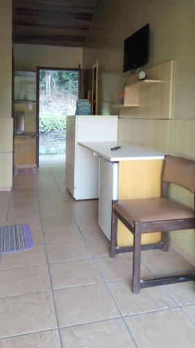 a kitchen with a desk and a chair in a room at Pousada Juriti - Eco Hotel in São Roque