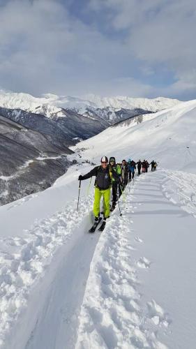 a group of people skiing down a snow covered slope at Vila Latphari in Ushguli in Ushguli