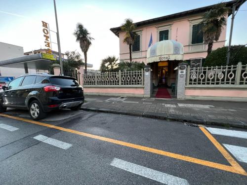 a car parked in a parking lot in front of a building at Hotel Villa Primavera in Pisa