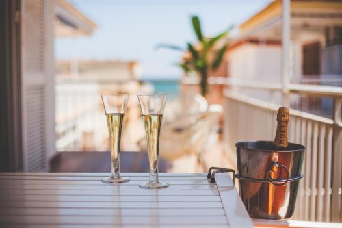 twee glazen champagne op een tafel op een balkon bij Apartamento con VISTAS AL MAR in Oliva