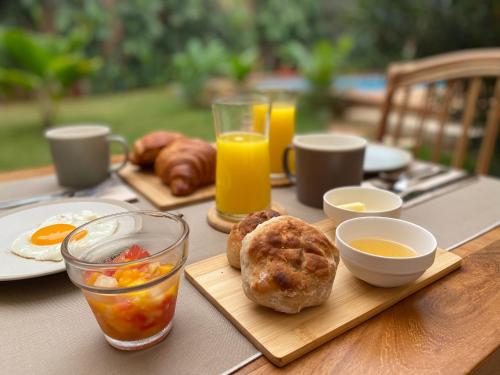 a wooden table with breakfast foods and drinks on it at Nomads in Lomé