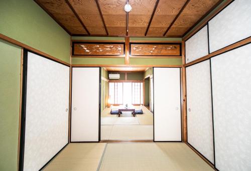 um corredor com portas e um quarto com uma mesa em Yokkaichi - House - Vacation STAY 68949v em Yokkaichi