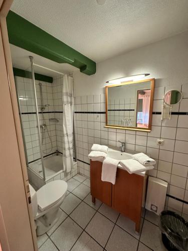 La salle de bains est pourvue d'un lavabo, de toilettes et d'un miroir. dans l'établissement Hafenbrise, à Tönning