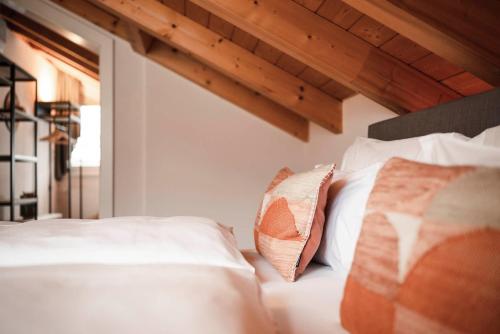 a white bed with two pillows on top of it at apartments55 in Bressanone