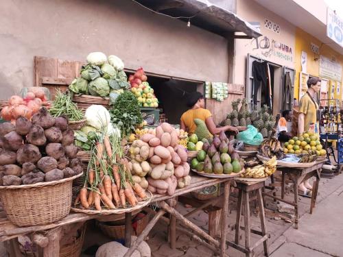 a market with lots of fruits and vegetables on tables at Maison fleurie Ouidah in Ouidah