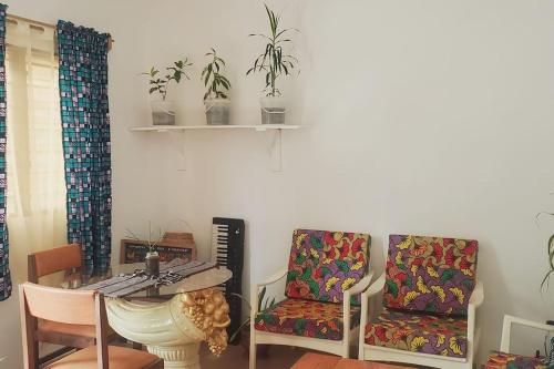 a living room with two chairs and a table at Maison fleurie Ouidah in Ouidah
