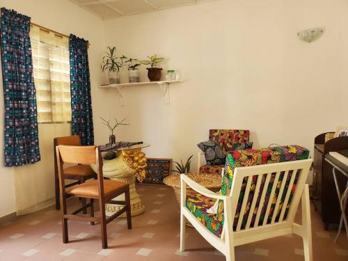 a living room with a table and chairs and a couch at Maison fleurie Ouidah in Ouidah