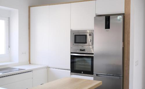 a kitchen with a stainless steel refrigerator and a microwave at AOVE Suite in Jaén