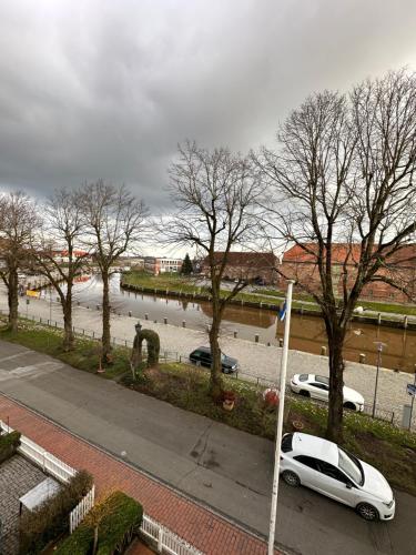 a white car parked on a street next to a river at Hafenbrise in Tönning