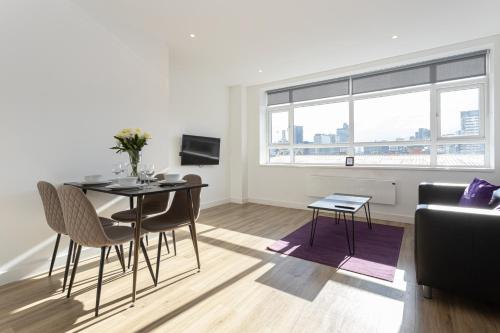 a living room with a table and chairs and a couch at Pillo Rooms Serviced Apartments - Manchester Arena in Manchester