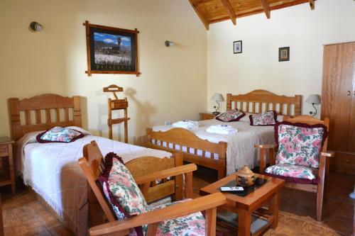 1 dormitorio con 2 camas, mesa y sillas en Lejana Patagonia en Esquel