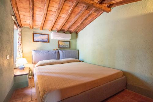 a bedroom with a bed in a room at PODERE TORRICELLE 69B Pancole Gr, seaview infinity pool, jacuzzi, sauna, exclusive villa with 2 bedrooms for 4 - If you total 5 or 6 people there is an independent suite in main villa with private ensuite bathroom, kitchenette and garden dining area in Pancole