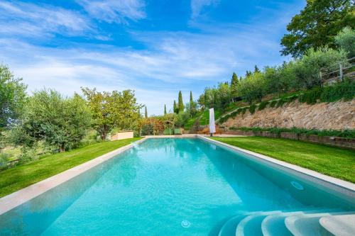 a swimming pool with blue water in a yard at PODERE TORRICELLE 69B Pancole Gr, seaview infinity pool, jacuzzi, sauna, exclusive villa with 2 bedrooms for 4 - If you total 5 or 6 people there is an independent suite in main villa with private ensuite bathroom, kitchenette and garden dining area in Pancole