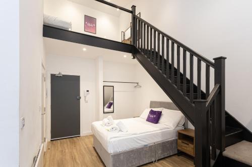 a bedroom with a bed and a staircase at Pillo Rooms Serviced Apartments - Manchester Arena in Manchester