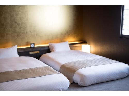 dos camas sentadas una al lado de la otra en una habitación en HOTEL SHIKISAI KYOTO - Vacation STAY 74839v, en Kioto