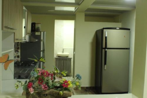 - une cuisine avec un réfrigérateur en acier inoxydable et des fleurs dans l'établissement DONDE MI MADRE, à Montenegro