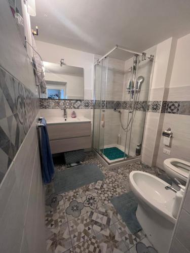 een badkamer met een douche, een toilet en een wastafel bij La casa del Sole in Imperia