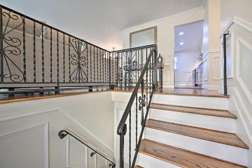 a staircase in a home with a wrought iron railing at Bay Shore Vacation Rental with Shared Yard! in Bay Shore