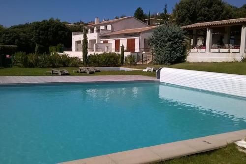 a large blue swimming pool in front of a house at Mont-Ventoux, Provence, Appartement avec vue panoramique et piscine in Mollans-sur-Ouvèze