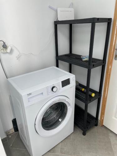 a washing machine in a room with a shelf at LES GITES DE LA RESERVE in Bouillante