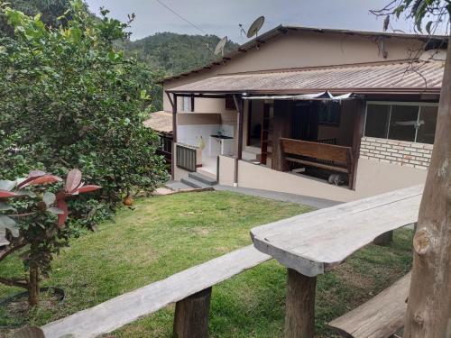 a wooden bench in front of a house at Casa Nirvana para Temporadas in Alto Paraíso de Goiás
