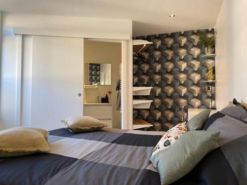 une chambre avec un grand lit avec des oreillers dessus dans l'établissement Appartement à découvrir, à Marquette-lès-Lille