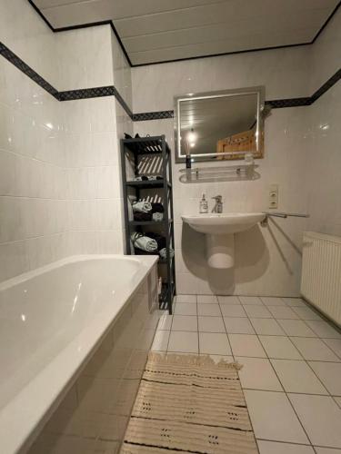 y baño con bañera, lavabo y espejo. en Haus Rubi, en Cochem
