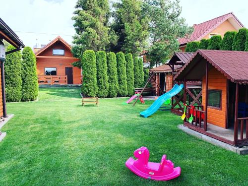 a yard with a playground with a slide at Domki Wczasowe Papaya in Kołobrzeg