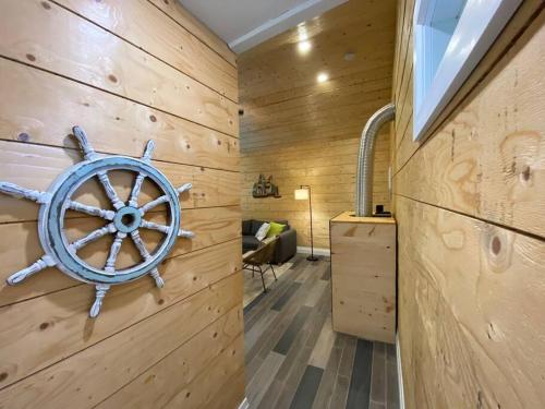 een kamer met een houten muur met een scheepswiel erop bij Disconnect From Reality/ River House/Hot Tub/Pet Friendly in Port Burwell